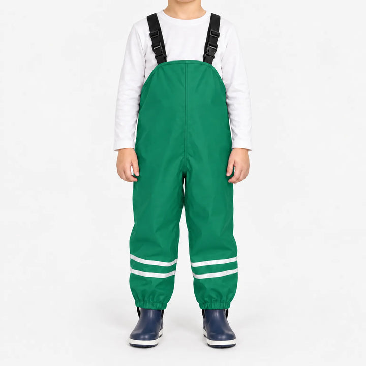 Front view of child wearing green waterproof overalls with black buckled straps, reflective ankle stripes and elastic cuffs, with navy boots. 10