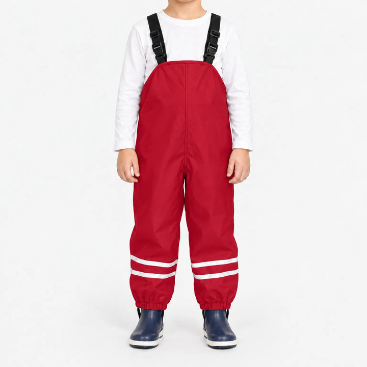 Front view of child wearing red waterproof overalls with black buckled straps and reflective stripes at the ankles, paired with navy boots. 11