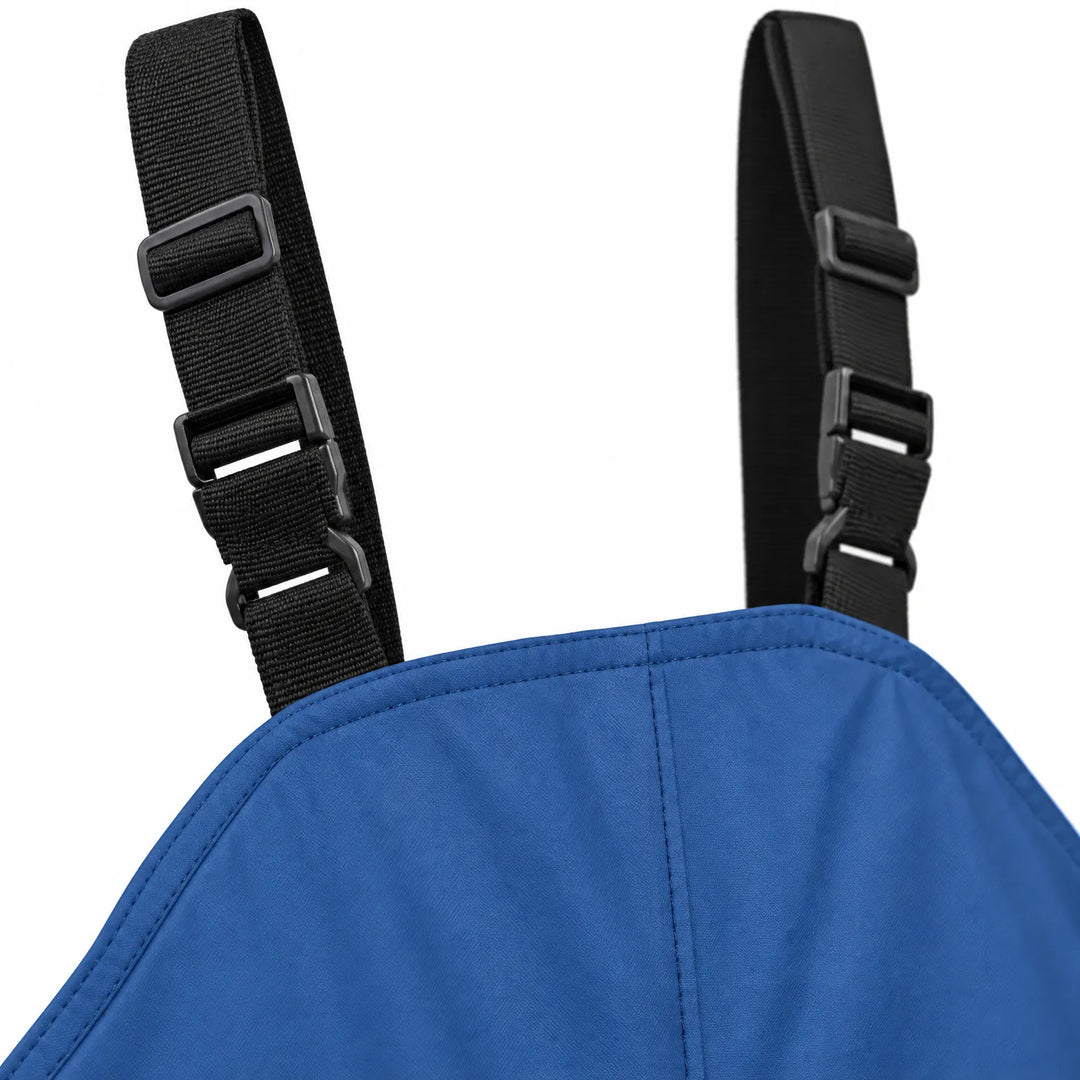 Close-up detail of the blue overalls' bib top and black adjustable shoulder straps with plastic side-release buckles and slide adjusters. 6