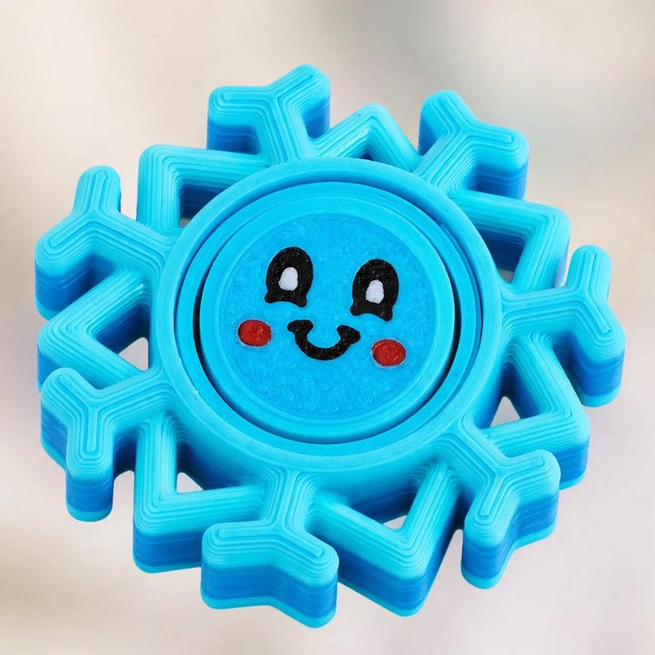Close-up of a blue layered snowflake spinner with a smiling face in the center 3
