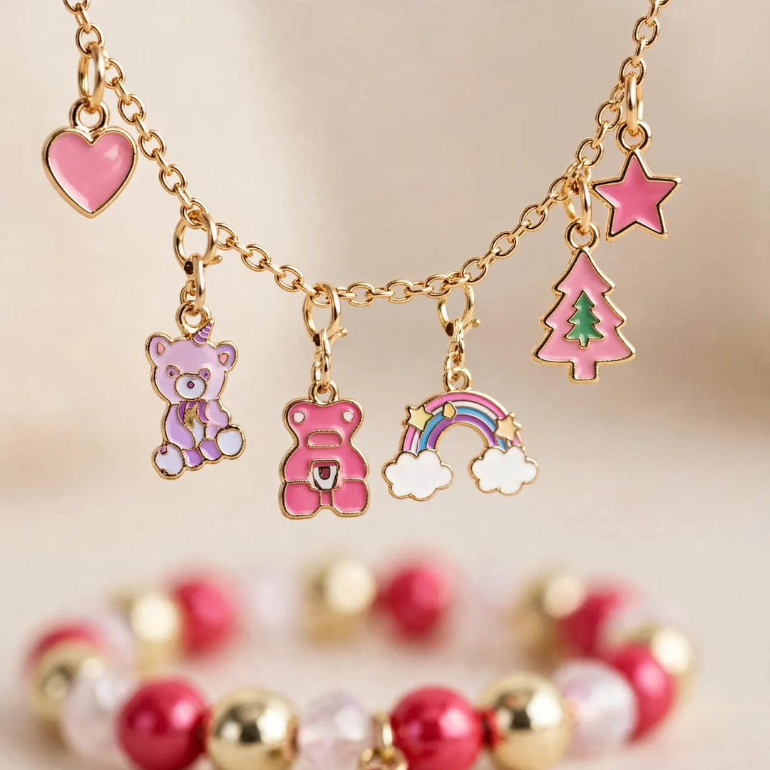 Close-up of a gold chain with pink enamel charms: heart, bears, rainbow, tree and star, above a beaded bracelet 3