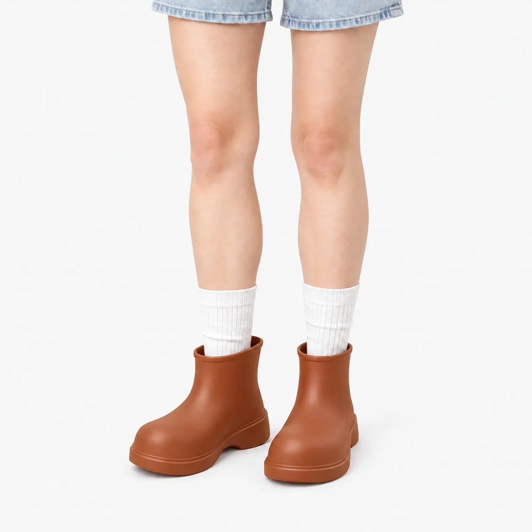 Brown ankle boots worn with white ribbed socks and denim shorts, front view on a white background. 7