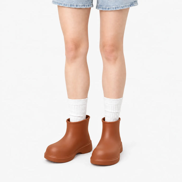 Brown ankle boots worn with white ribbed socks and denim shorts, front view on a white background. 7
