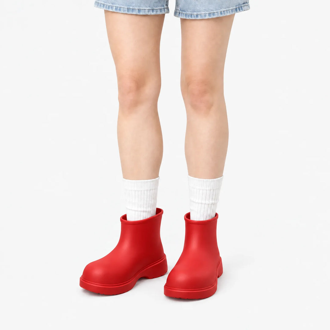 Bright red ankle boots worn with white ribbed socks and denim shorts, front view on a white background. 8