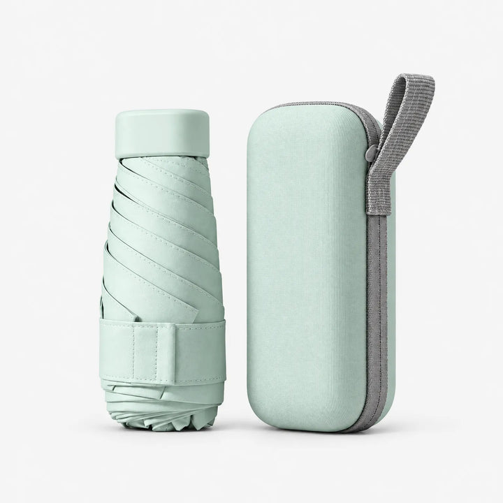 Folded mint green umbrella with cap and strap beside its matching zippered hard case with a gray carrying loop. 2