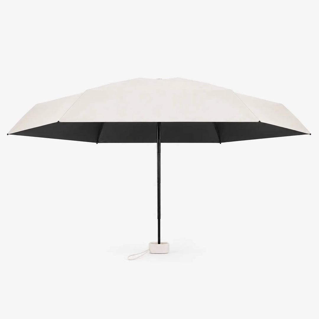 Open cream umbrella seen from the side, showing a black underside, slim black shaft and a small cream base with a loop. 4