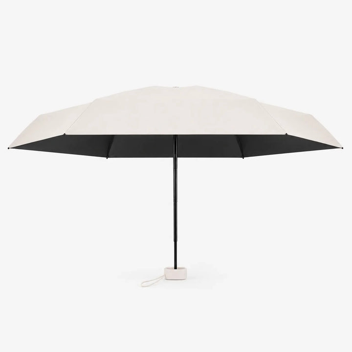 Open cream umbrella seen from the side, showing a black underside, slim black shaft and a small cream base with a loop. 4