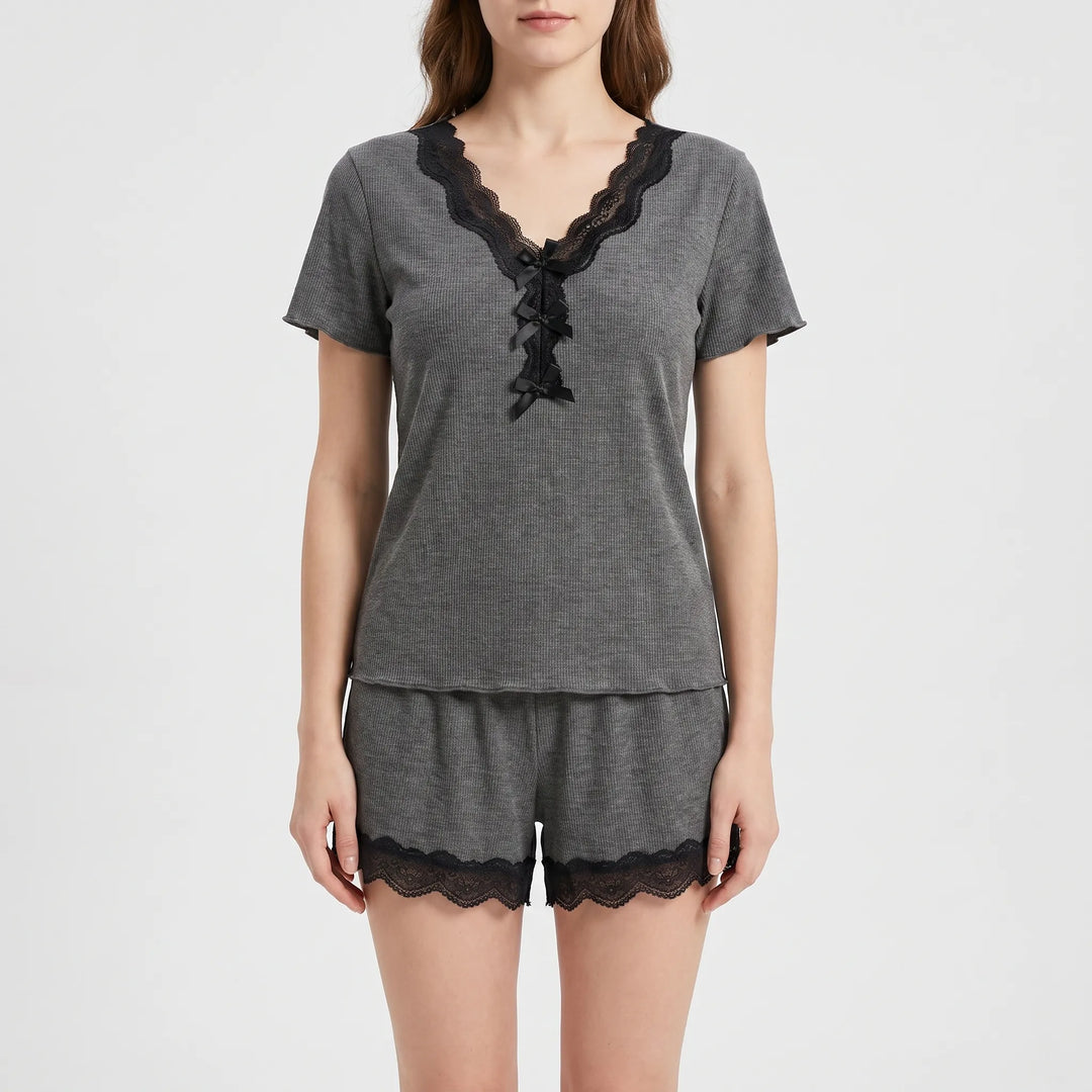 Front view on a model in the gray ribbed pajama top with black lace V-neckline, three small black bows, and shorts with black lace hems. 2