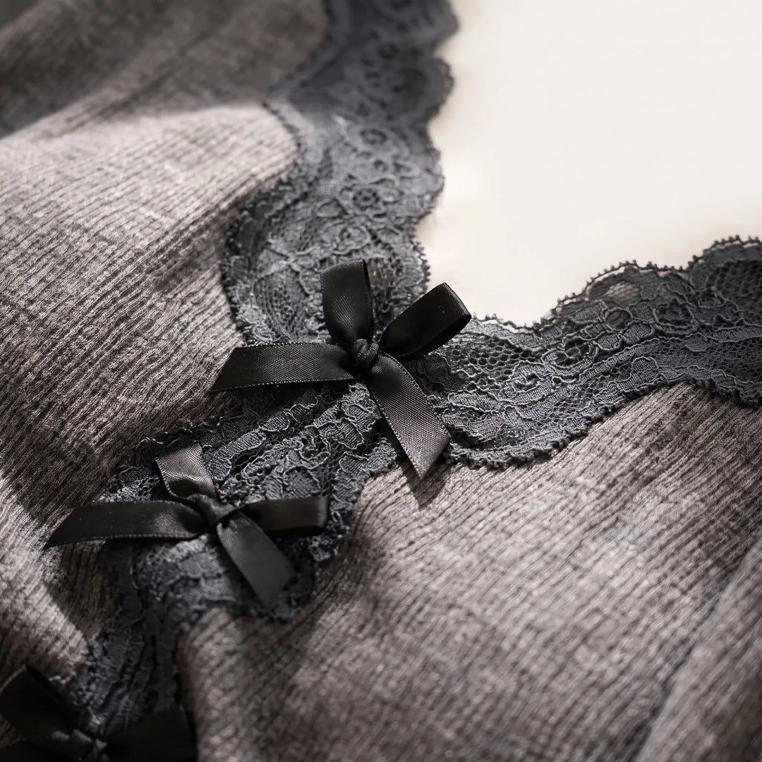 Close-up of the V-neckline detail on the gray ribbed fabric, showing black floral lace edging and small black satin bows. 5