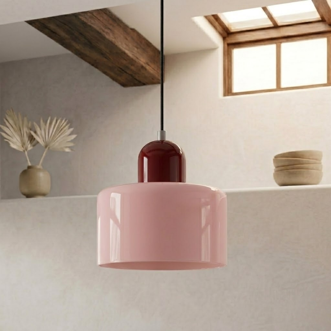 Pink glossy drum shade paired with a deep burgundy cap, suspended by a black cord in a bright, plastered interior. 3