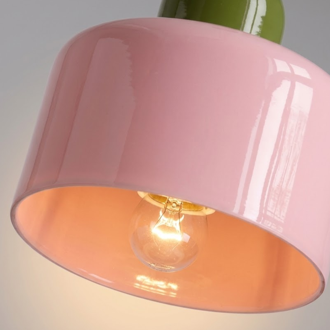 Close-up of a pink glossy shade with an olive green cap, showing a clear bulb glowing inside. 37
