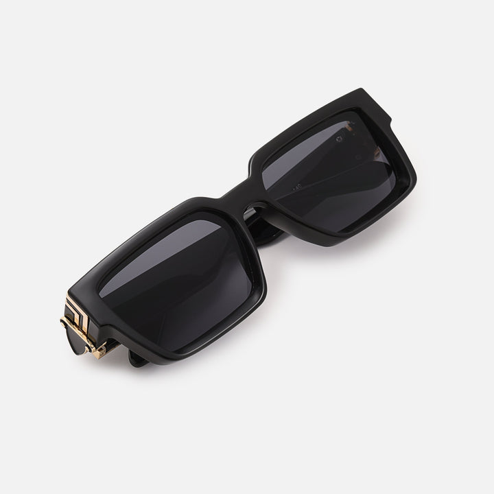 Folded black sunglasses with gold hinge detail, viewed from above at an angle. 10