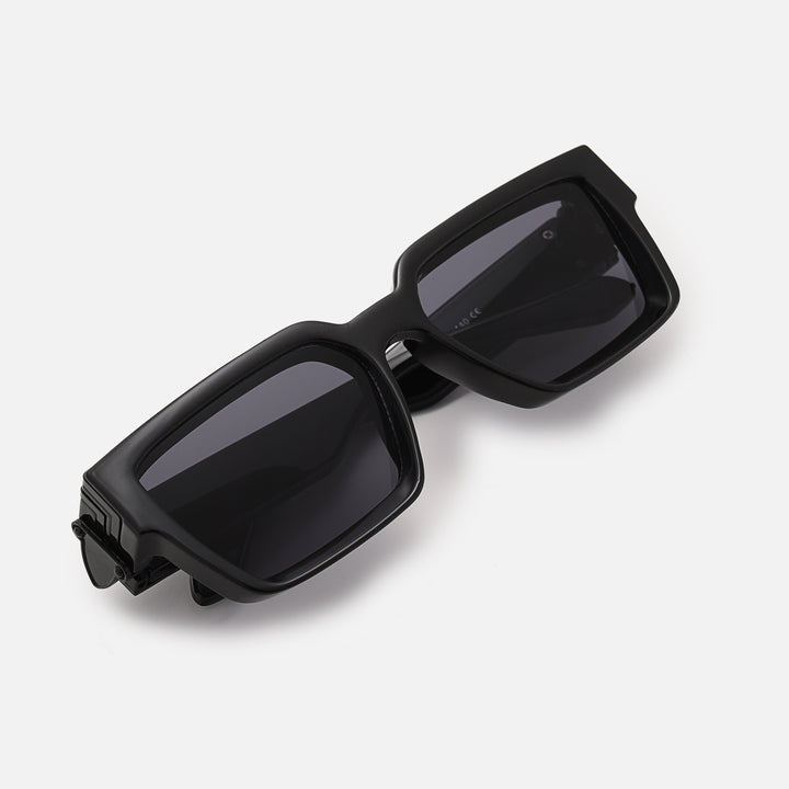 Folded black sunglasses with dark lenses, viewed from above at an angle, showing the hinge plate. 3