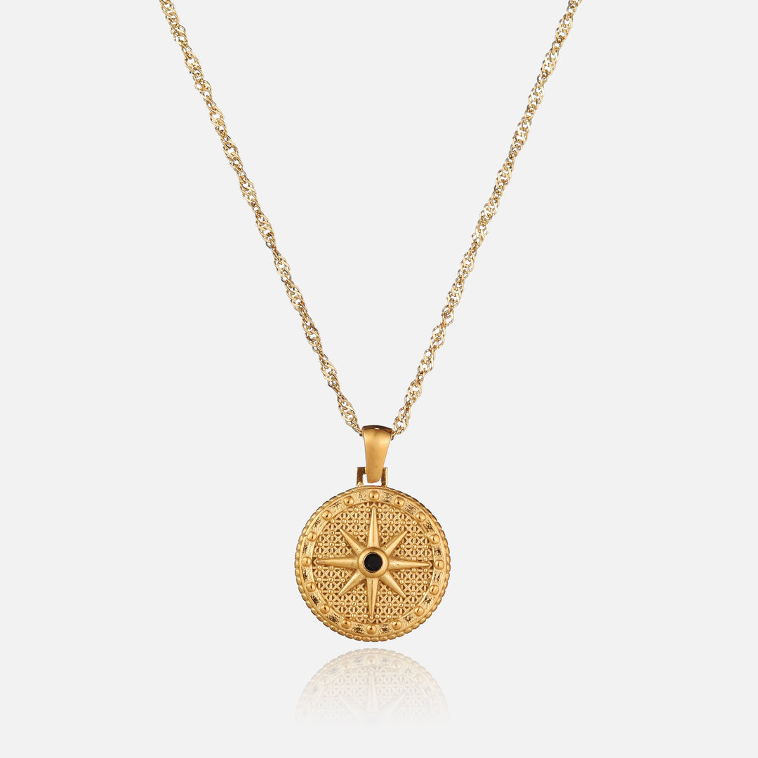 Front view of a round gold pendant with an eight-point star and black stone on a twisted chain 1
