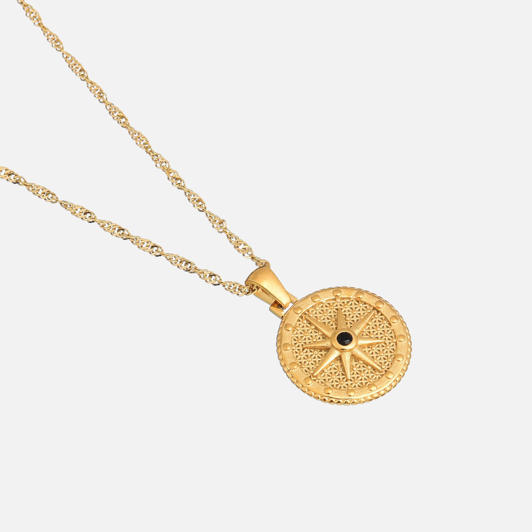 Angled close-up of the round pendant showing its beaded rim, star design and twisted chain 2