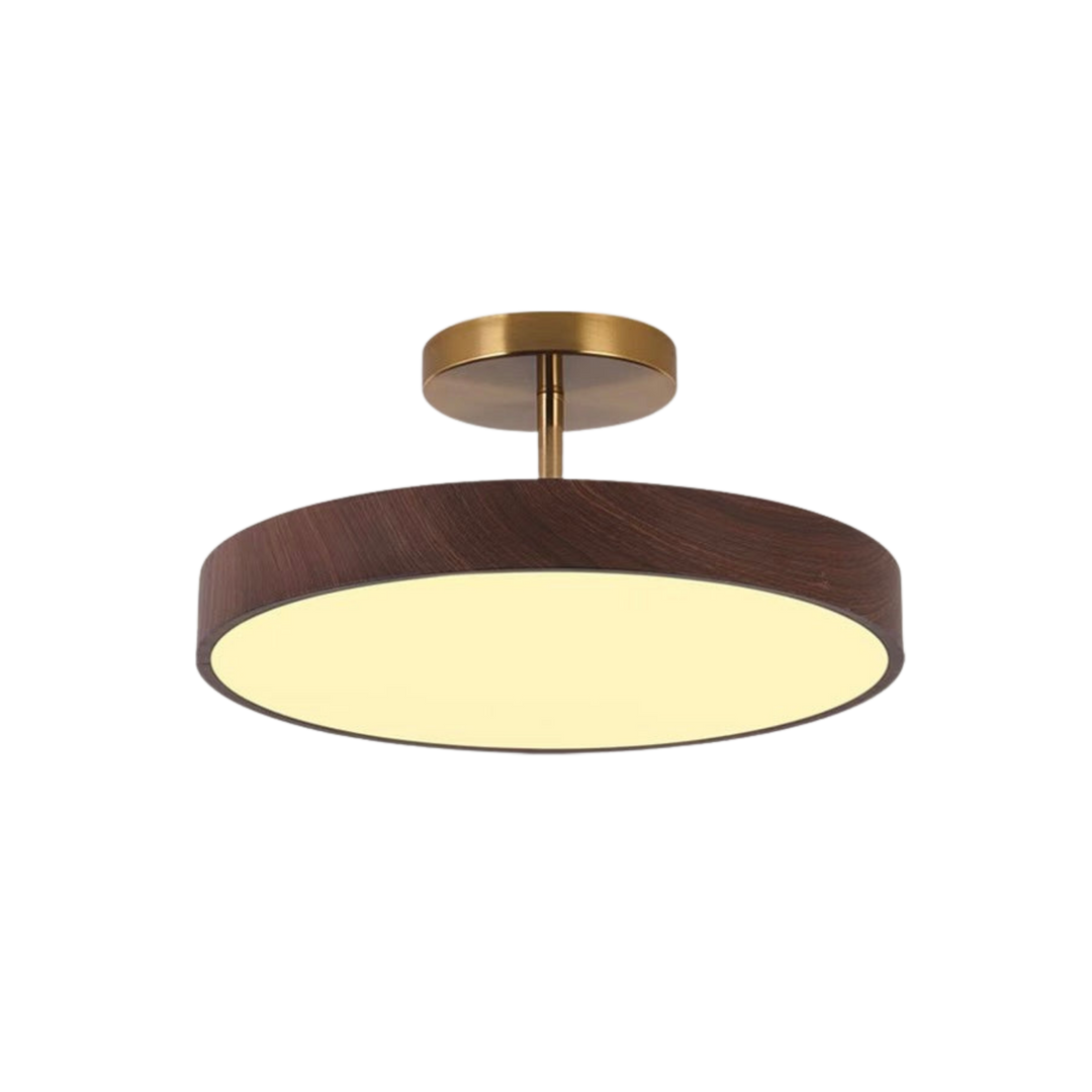 Dark wood-look disc ceiling light with brass-tone mount and stem, lit with a warm glow, shown alone on a white background.