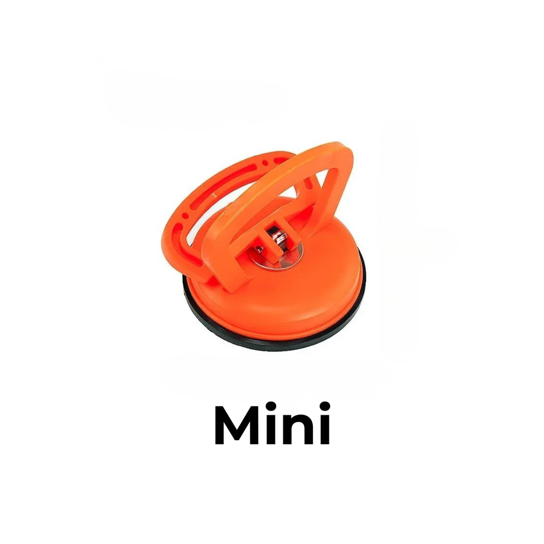 Small orange suction cup dent puller with a metal center fitting and black rubber seal on a white background.