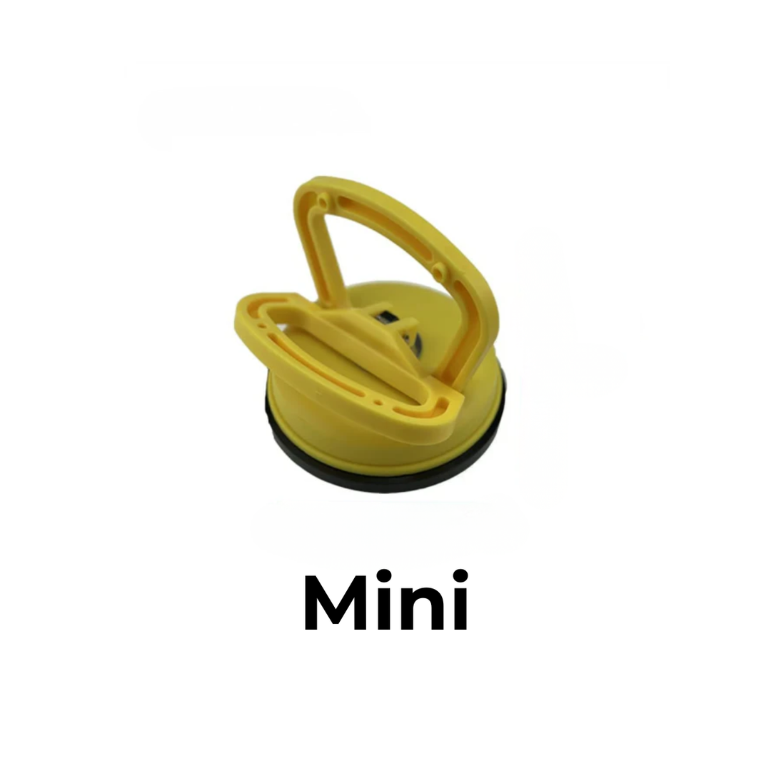 Small yellow suction cup dent puller with a folding handle and black rubber seal on a white background.