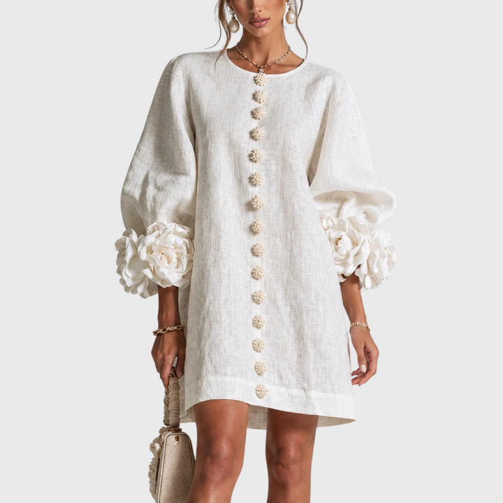 White linen mini dress with puff sleeves and flower buttons, front view.