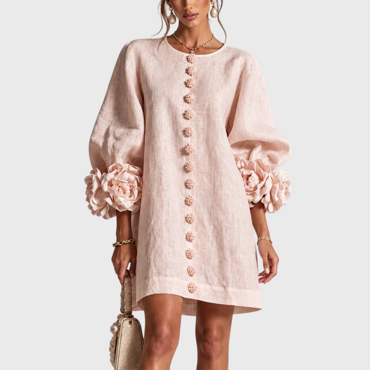 Soft blush pink linen mini dress with puff sleeves and flower buttons, front view.