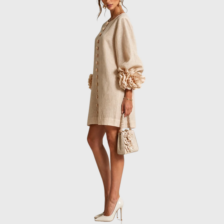 Beige linen mini dress with puff sleeves and flower buttons, side view.