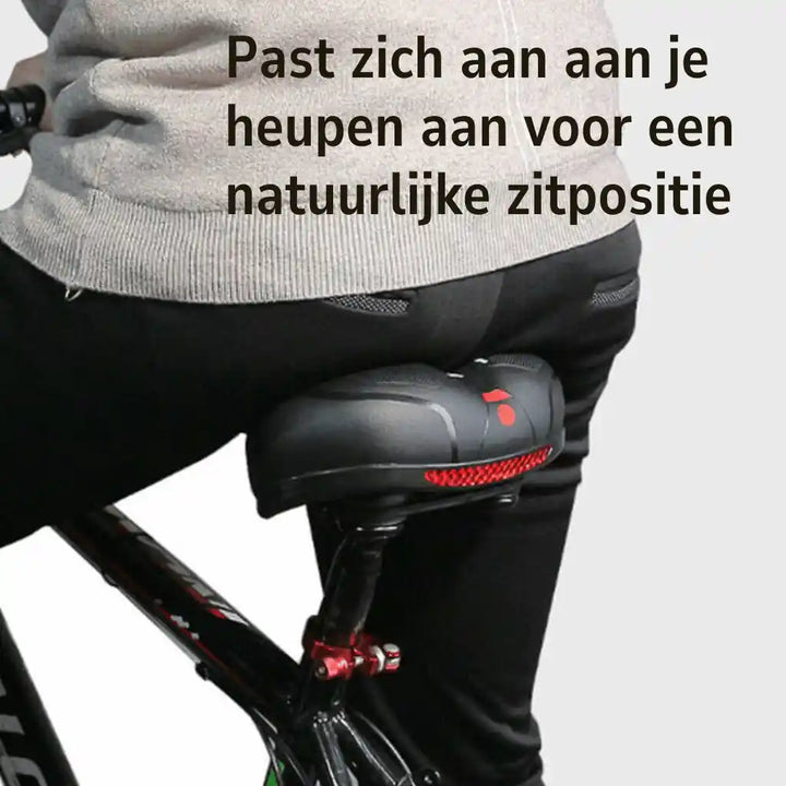 Close rear view of a rider seated on the saddle, showing how the wide shape supports the hips. 6