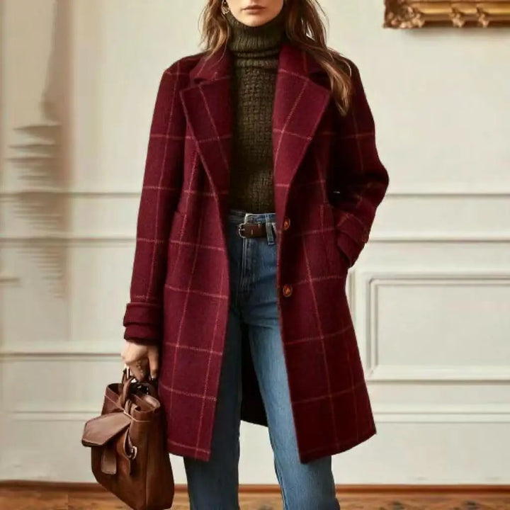 Model wearing the checked coat in burgundy red with light lines, over a turtleneck and jeans 10