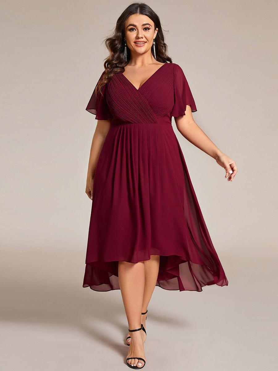 Plus-size model wearing the burgundy chiffon dress with black heels and tassel earrings, walking forward with the skirt flowing. 49