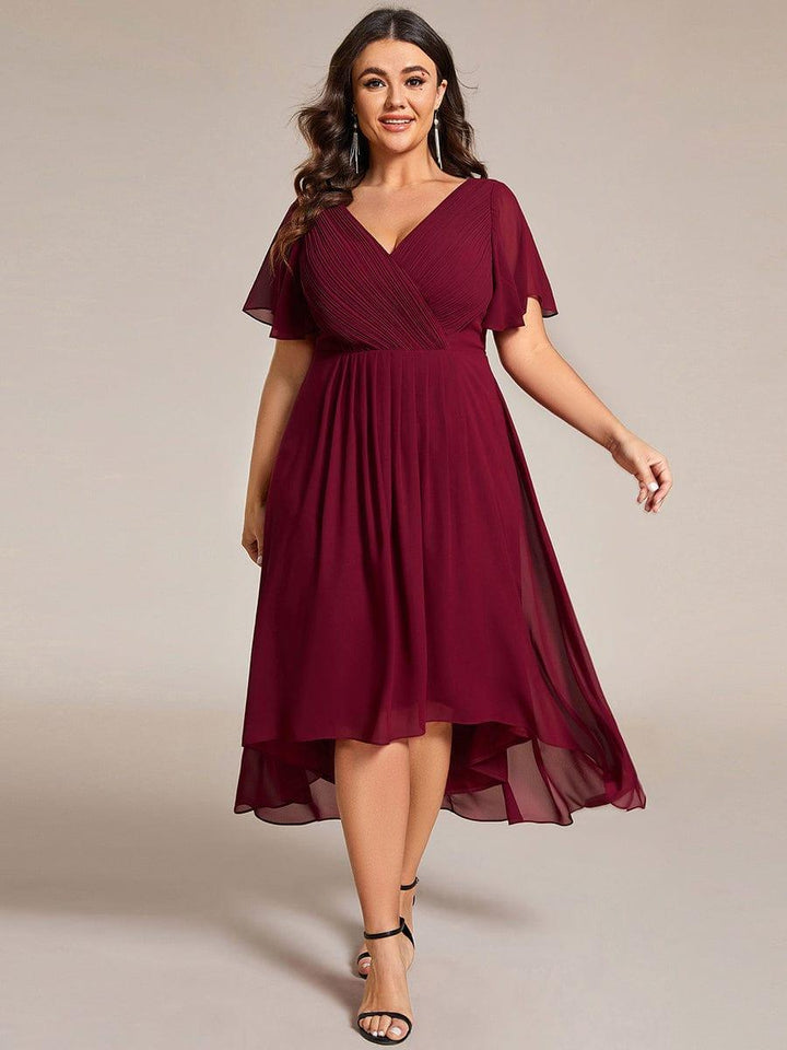 Plus-size model wearing the burgundy chiffon dress with black heels and tassel earrings, walking forward with the skirt flowing. 49