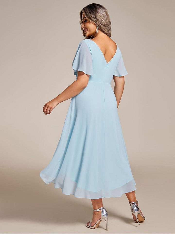 Back view of the light blue chiffon dress on a plus-size model, showing zipper, V back and flowing layered hem. 90
