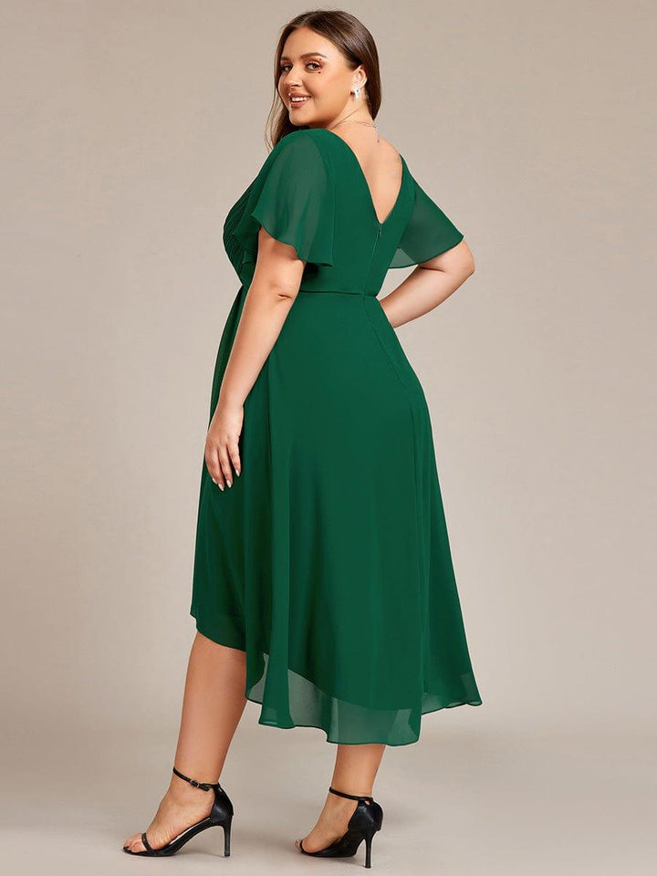 Back view of a plus-size model in the dark green dress, glancing over her shoulder, showing the V back and zipper. 37