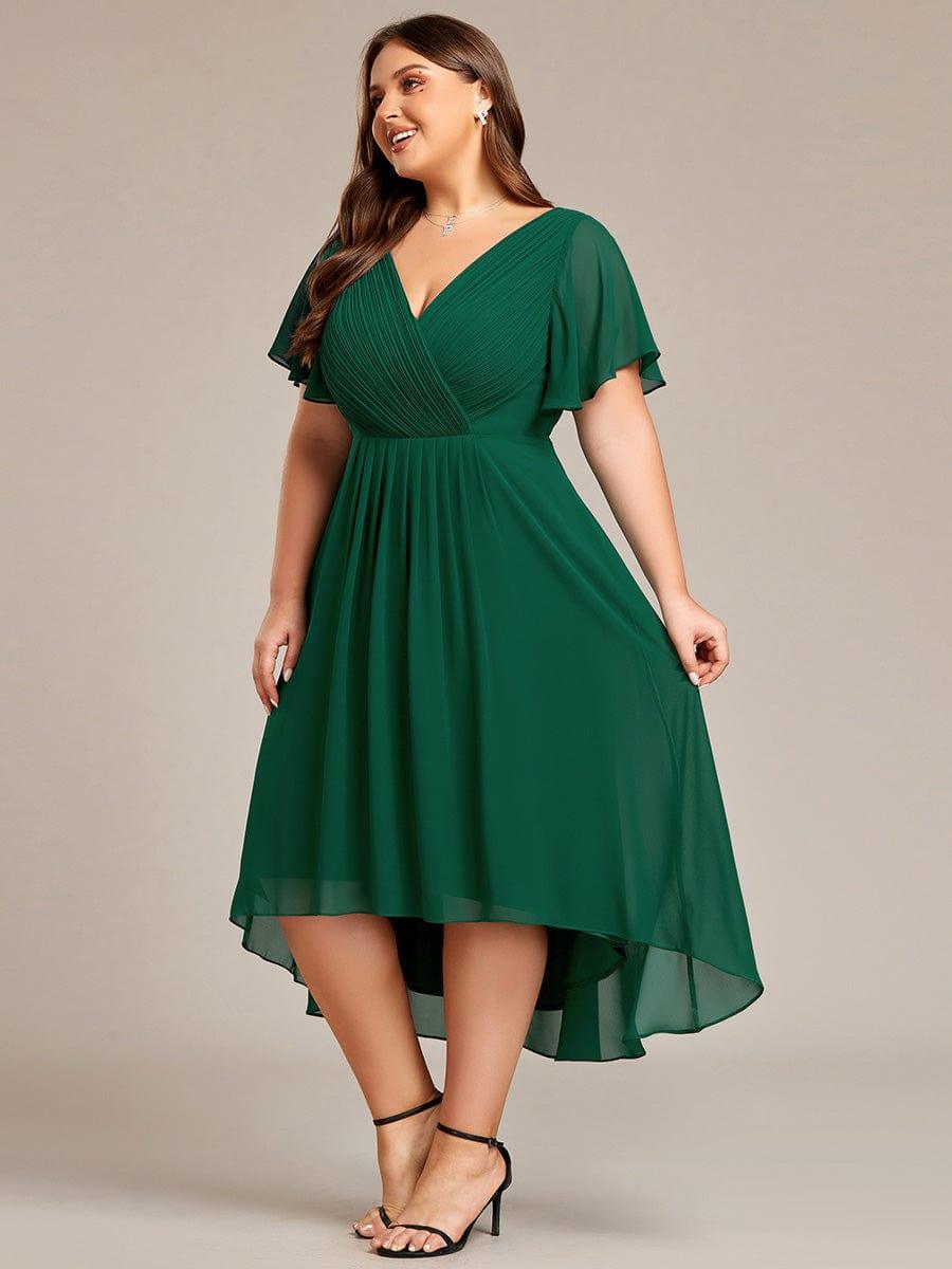 Plus-size model in the dark green dress, turned to the side and smiling, showing the pleated waist and layered chiffon hem. 39