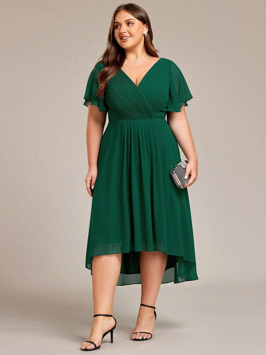 Plus-size model in the dark green chiffon dress holding a sparkly clutch, front view with black strappy heels. 40