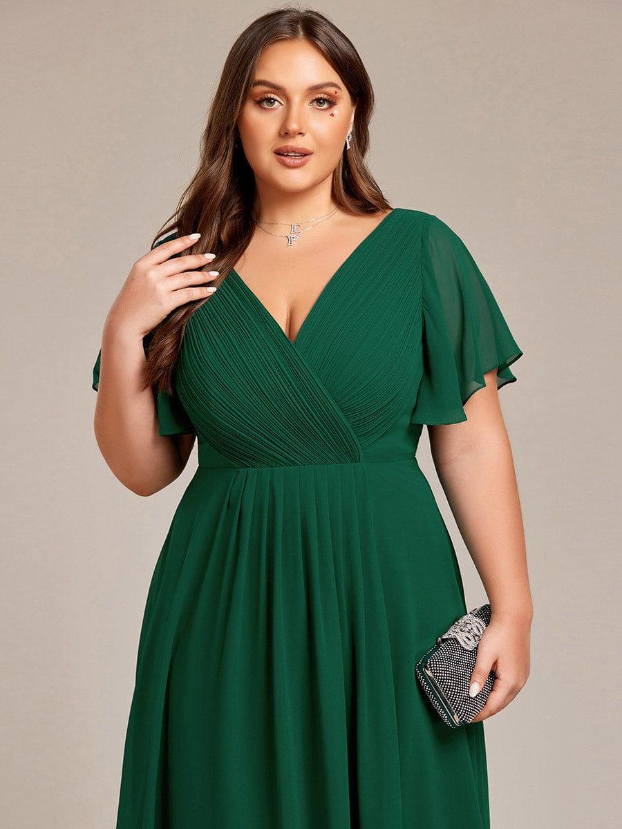Close-up of a plus-size model in the dark green dress, showing the pleated V-neck bodice and sheer sleeves, with a rhinestone clutch. 38