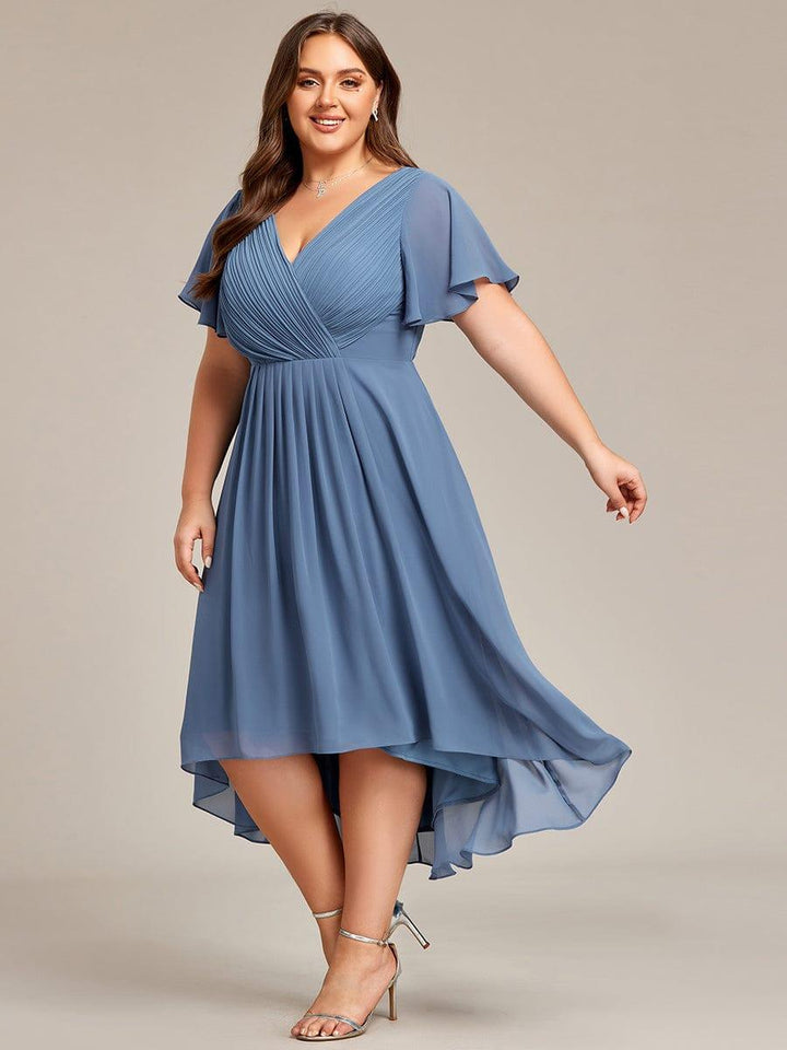 Three-quarter view of the dusty blue chiffon dress in motion, the high-low skirt swirling as the plus-size model steps. 45