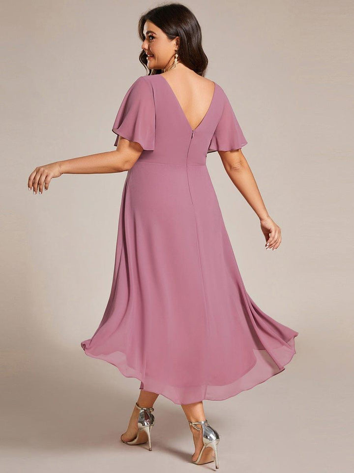 Back view of a plus-size model in the mauve pink dress, showing the low V-back, zipper and flowing high-low hem. 64