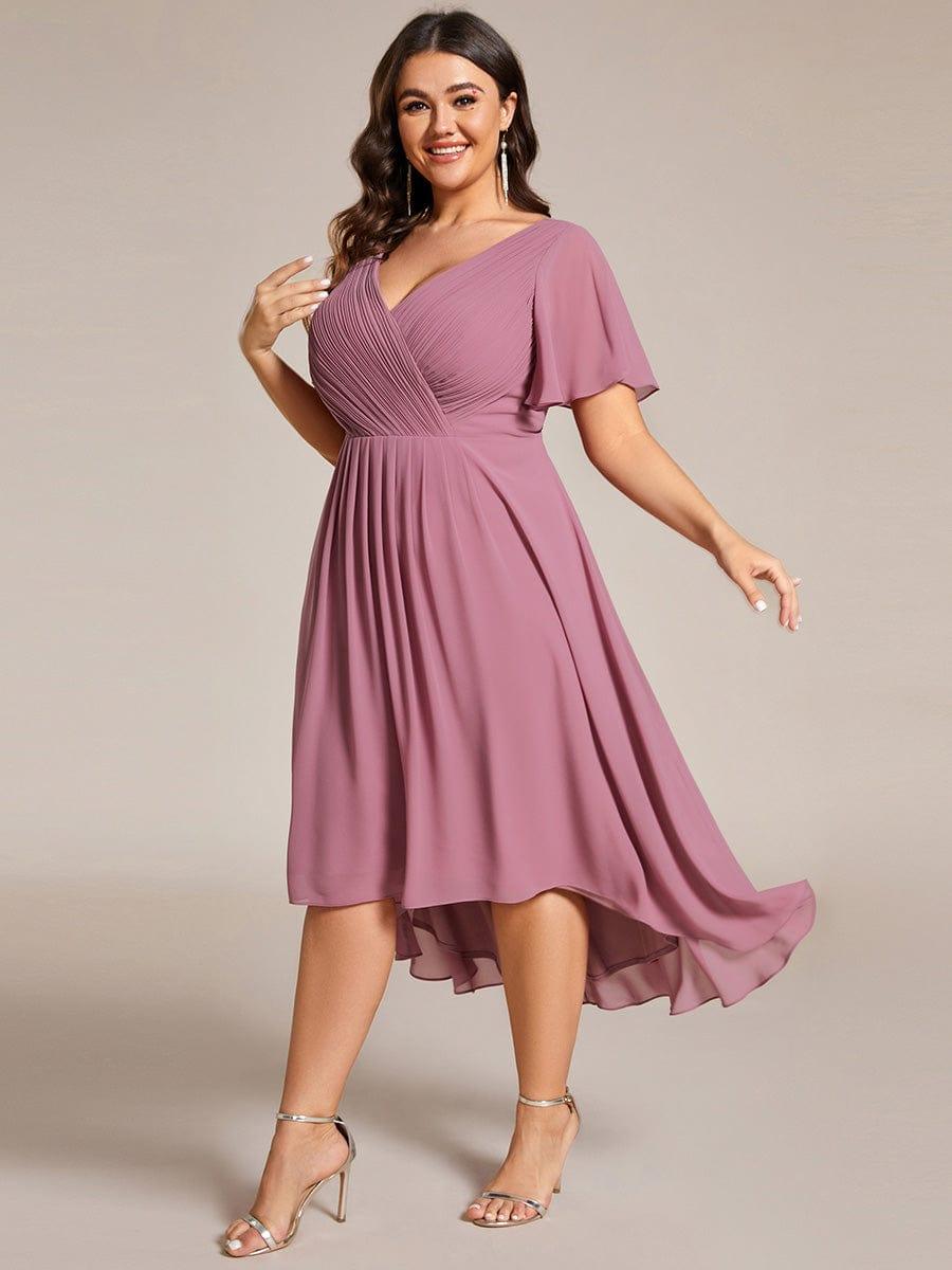 Three-quarter view of a plus-size model in the mauve pink dress, skirt swinging to show the high-low chiffon hem. 67