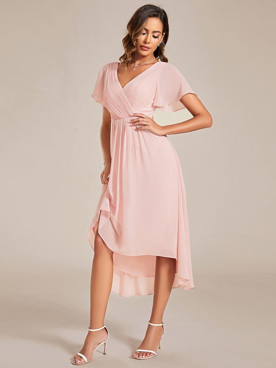 Pink chiffon dress with the model lifting the skirt slightly to show the layered high-low hem. 19