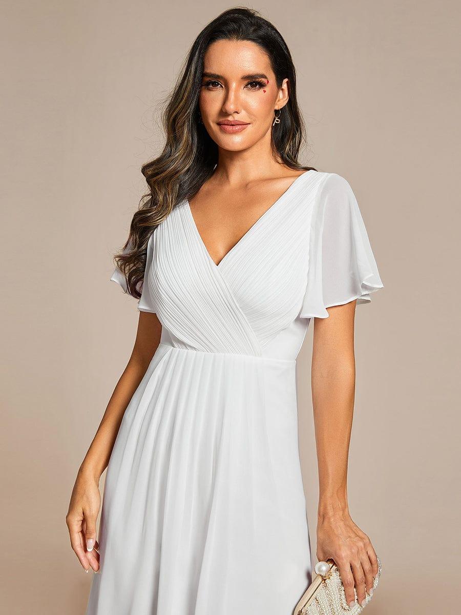 Close-up of the white chiffon dress on a model, showing the pleated wrap V-neckline and sheer flutter sleeves. 70