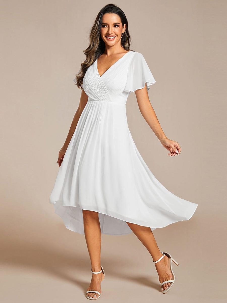 Model in the white chiffon dress mid-twirl, skirt flaring to show the high-low hem and light, airy fabric. 72