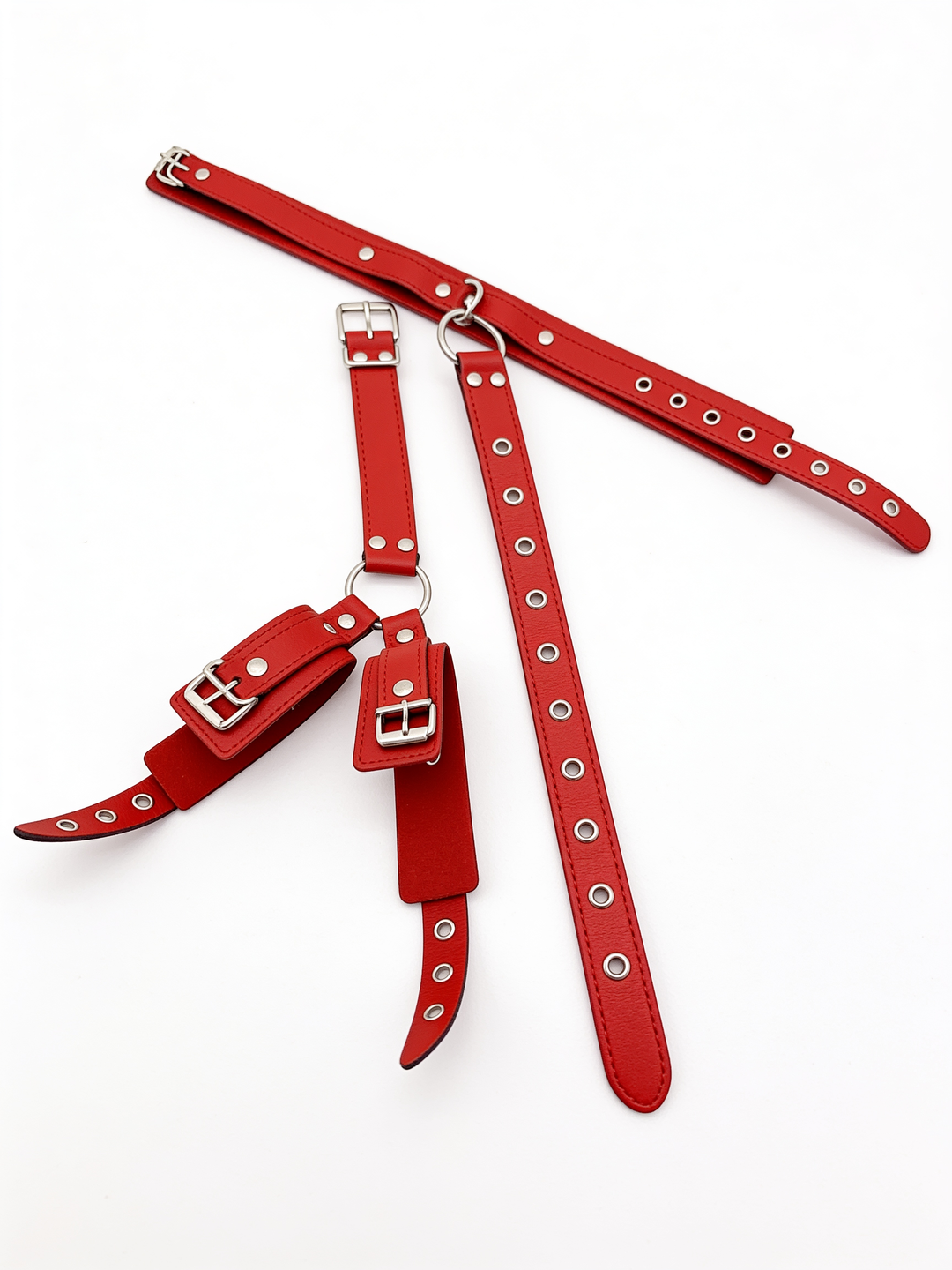 Red set disassembled on white, showing the collar, the long eyelet strap and the cuff section with buckles and metal rings. 11