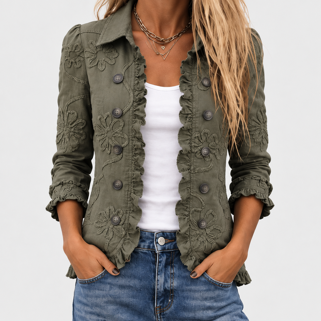 Bohemian floral embroidered olive green jacket open over a white tank and jeans with ruffled edges and buttons.
