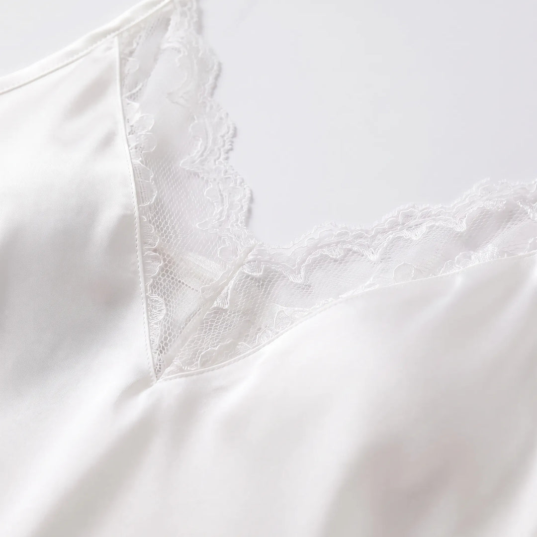 Close-up detail of the slip's V-neckline with scalloped white lace panel against smooth satin fabric. 5
