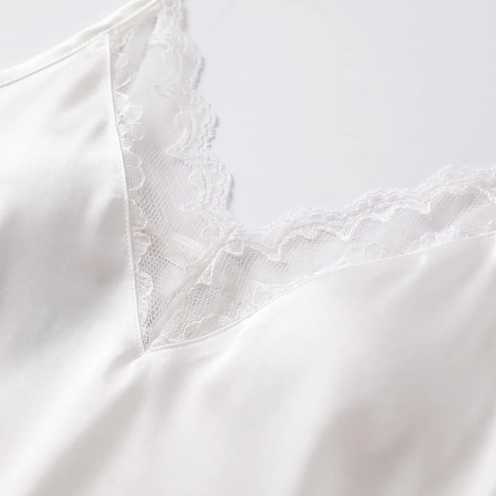 Close-up detail of the slip's V-neckline with scalloped white lace panel against smooth satin fabric. 5