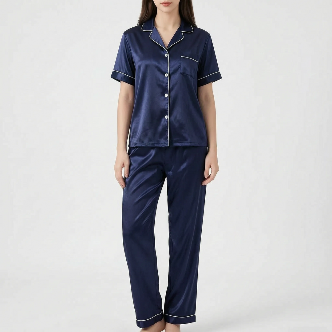 Woman in the navy blue satin version of the pajama set with white piping, shown from the front. 8