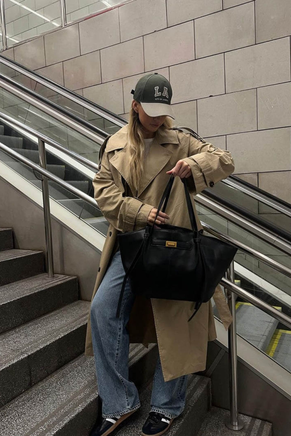 Black nylon tote detail held open by its straps on a staircase.