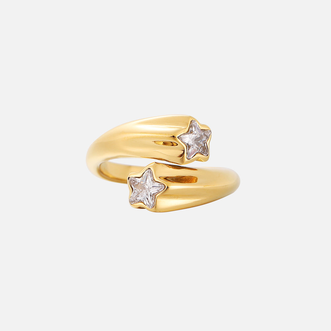 Gold wraparound ring with two star-shaped clear crystals at the open ends, shown from the front on a plain light background. 1