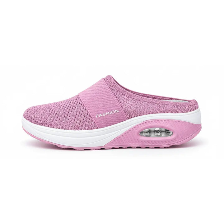 Side view of a single pink mesh mule showing the elastic strap, white midsole and air cushion in the heel.