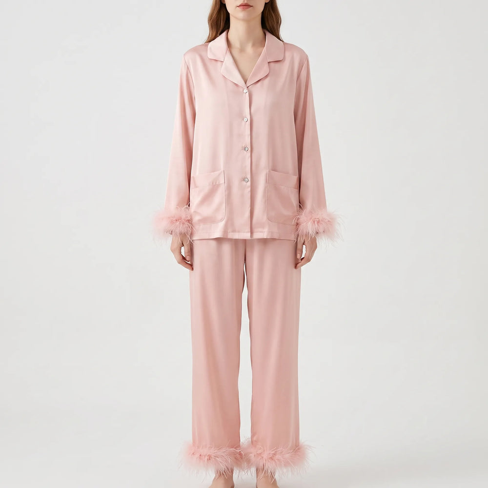 Front view on a model of the pink satin pajama set with notched collar, two chest pockets and fluffy feather trim. 2