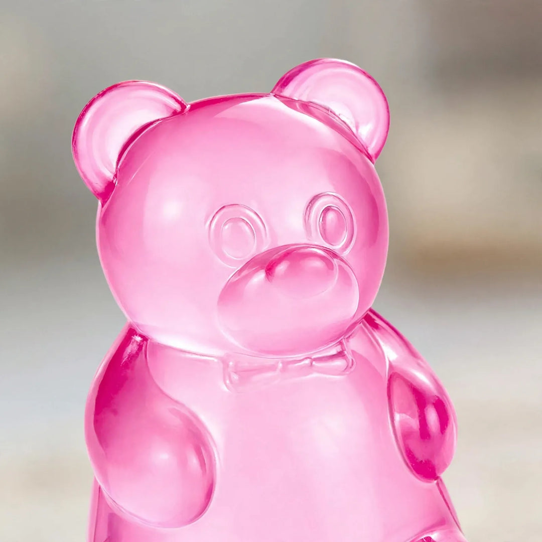 Close-up of a translucent pink gummy bear figure with a small bow tie on its chest 3